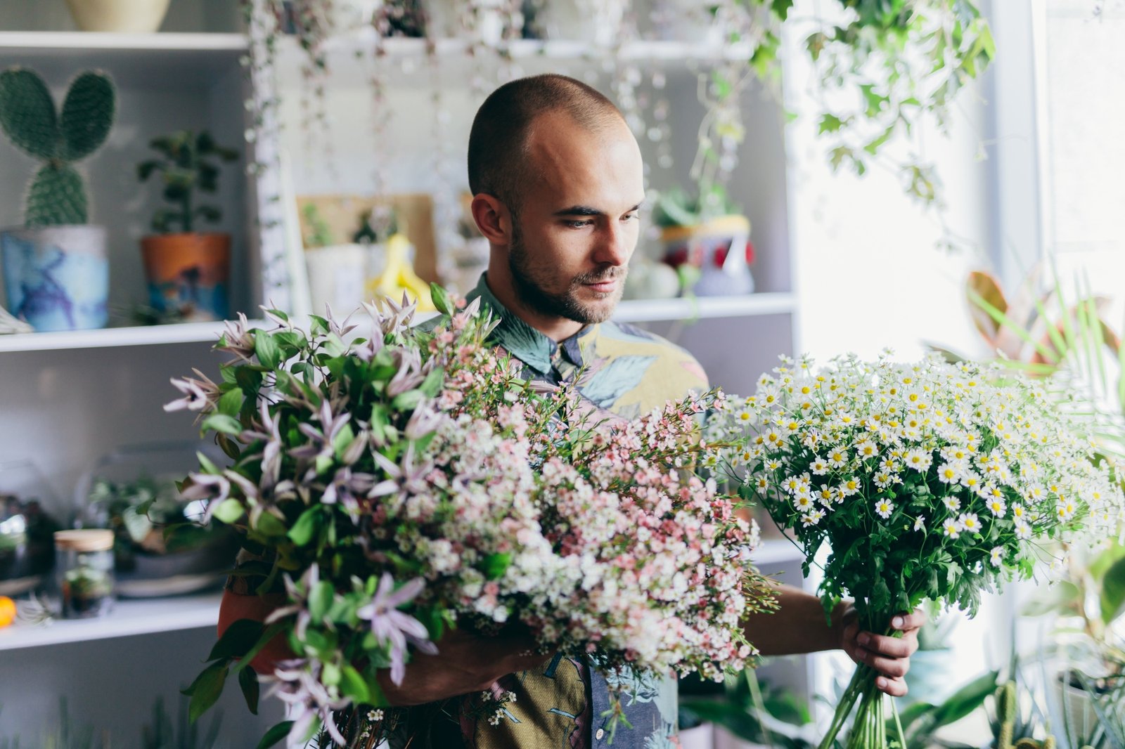 Man with bouquet from fresh flowers in florist shop