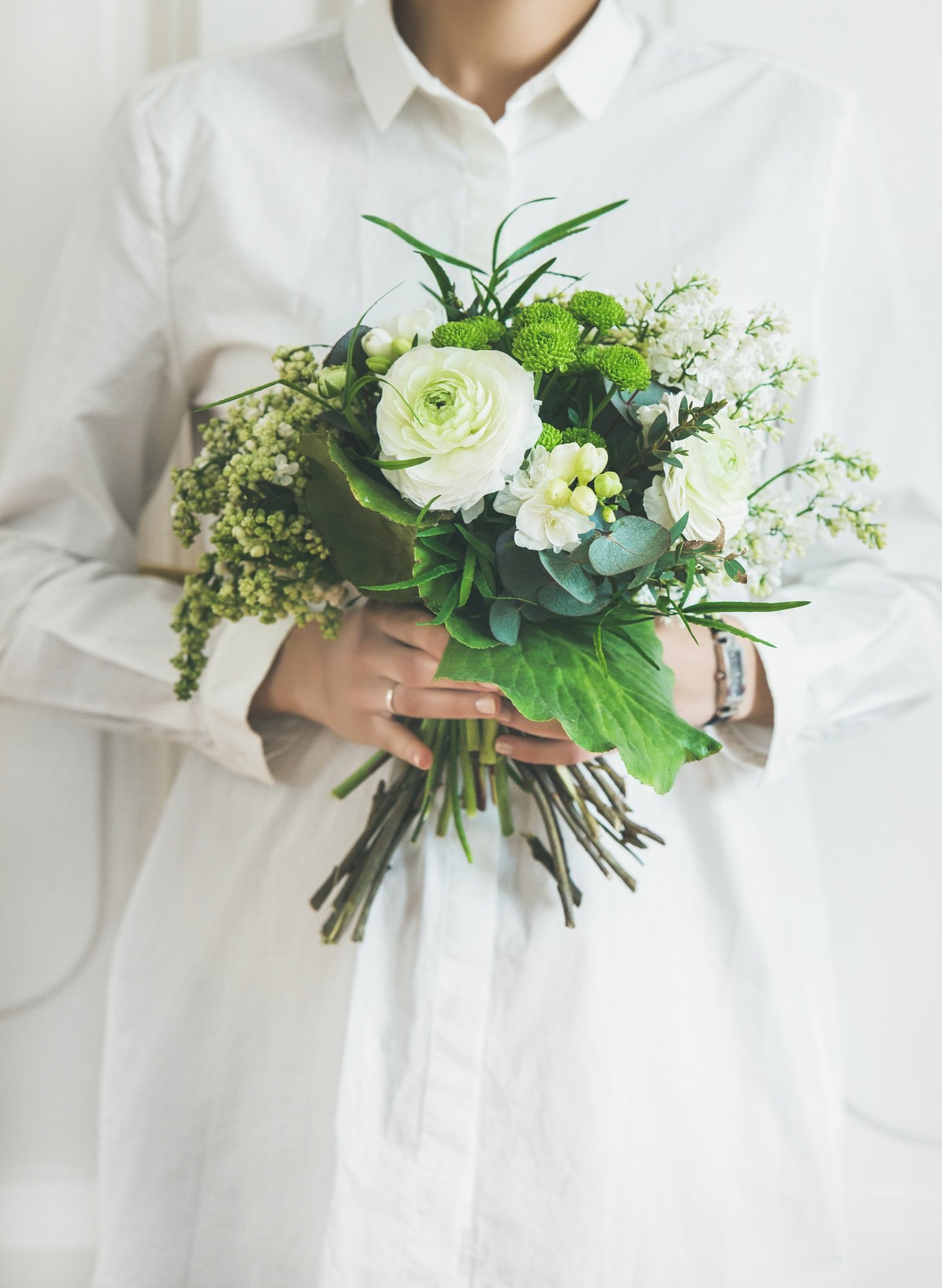 Young woman wearing white clothes holding bouquet. Flower shop concept